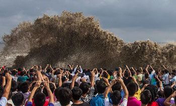 In the moment… snap-happy onlookers taking pictures of tidal waves after a typhoon in China. | Chance Chan / Reuters