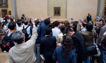 Tourists photographing the Mona Lisa in the Louvre in Paris. | Imagebroker / Alamy