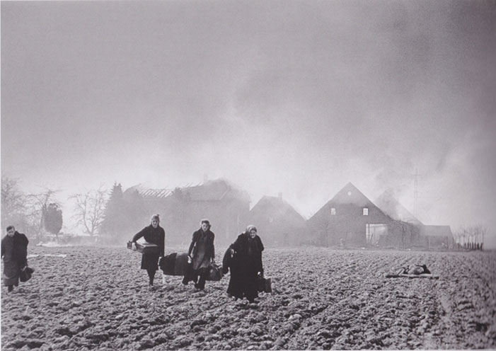 Dark figures on a light ground. Refugees near Wesel Germany. March 24th 1945. | Robert Capa